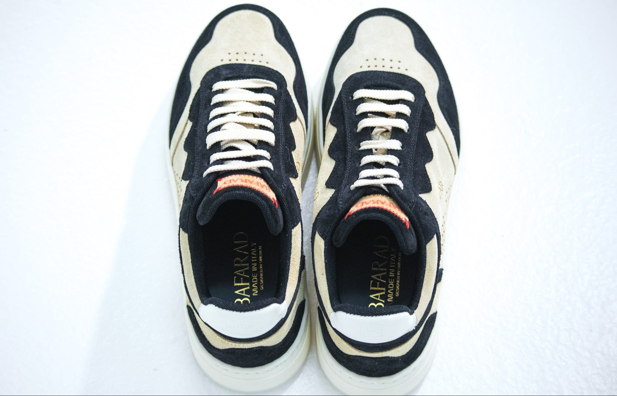 Pair of black and white sneakers with visible brand logo on a white background