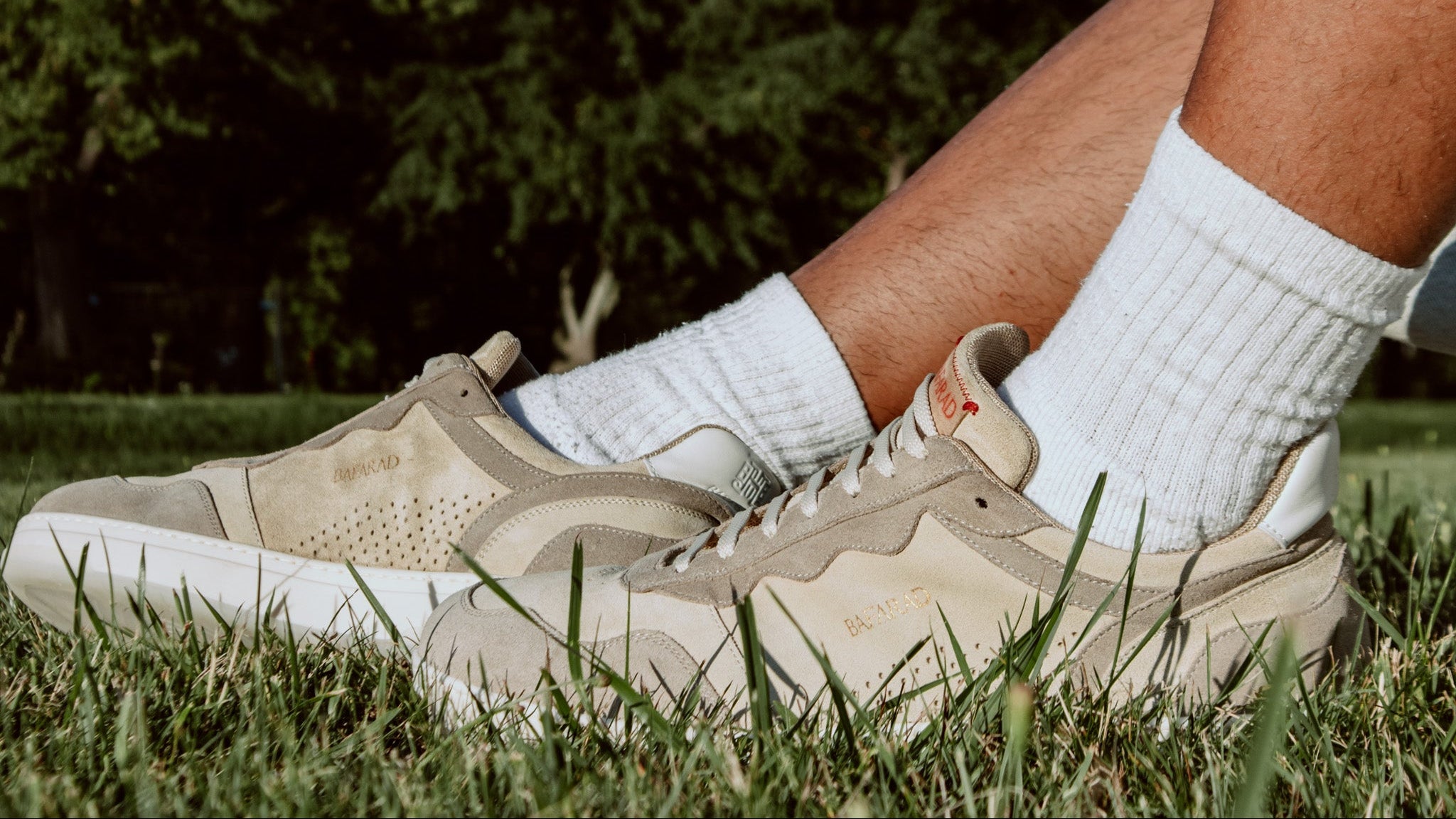 Beige sneakers and white socks on a grassy background