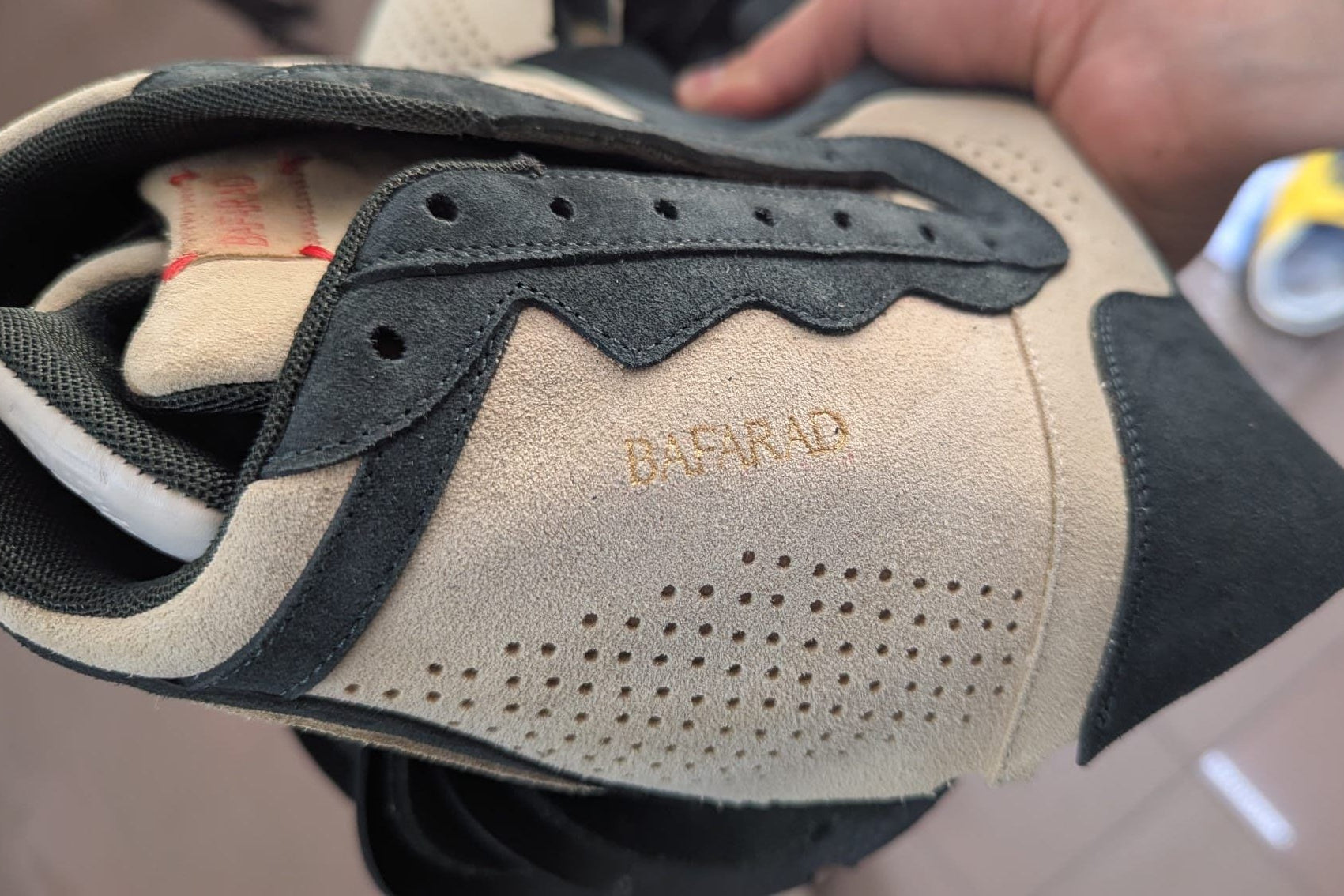 Close-up of a beige and black sneaker with 'Bacca Bucci' branding.